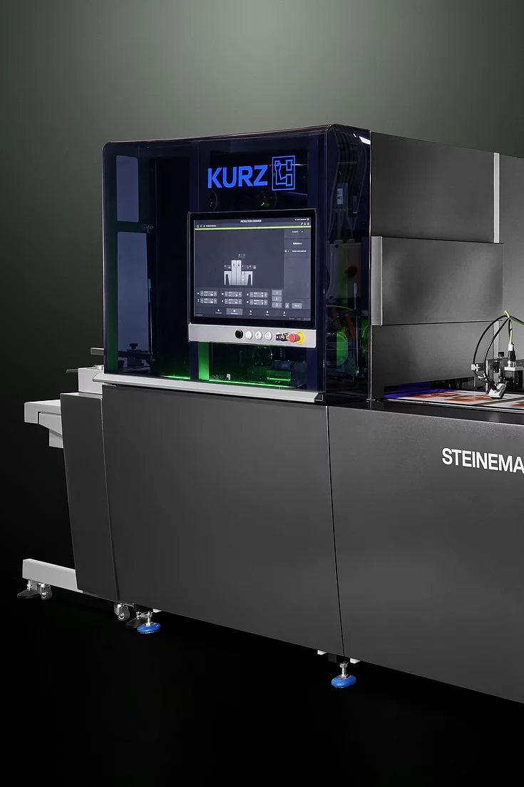 High-tech KURZ digital embellishment machine with touchscreen and colorful printed material.